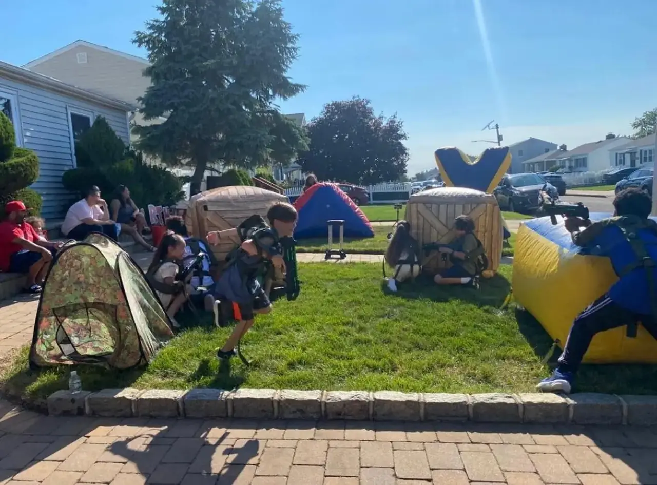 Laser tag obstacles and tents set up on a sunny lawn